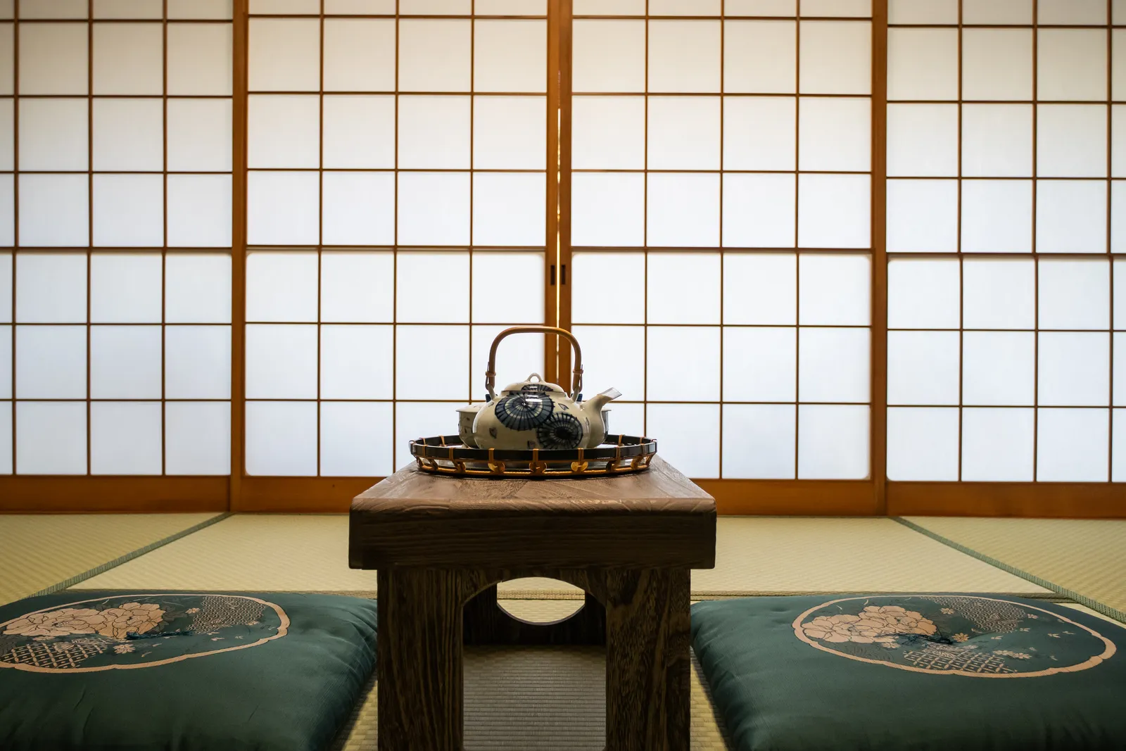 畳の間に据えられた膳。急須と器が並び、両脇に座布団が置かれている